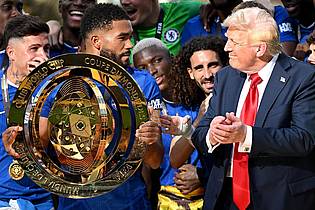 Sven Hoppe/dpa | Chelseas Kapitän Reece James (l/vorn) hält auf dem Siegerpodest die Trophäe in den Händen und schaut irritiert zu US-Präsident Donald Trump.