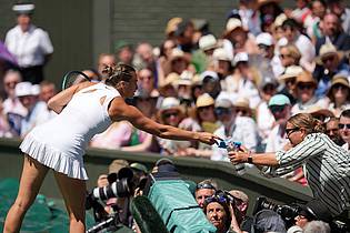 Kin Cheung/AP/dpa | Aryna Sabalenka bringt eine Wasserflasche und ein Kühlpack zur Tribüne, wo es einer Zuschauerin nicht gut geht.