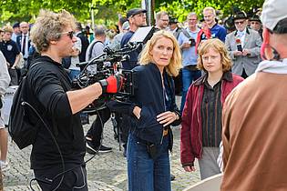 Julian Stratenschulte/dpa | Die Schauspielerinnen Maria Furtwängler (l) und Luise von Stein spielen eine Szene bei Dreharbeiten für einen neuen fiktiven ?Tatort? inmitten des realen Schützenausmarsches am Neuen Rathaus. 