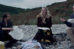 -/Universal Pictures/dpa | Tom Basden (l) als Herb McGwyer, Carey Mulligan als Nell Mortimer und Tim Key als Charles Heath in einer Szene des Films «The Ballad Of Wallis Island» (undatierte Filmszene). 