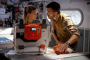 Jasin Boland/Universal Pictures/dpa | Scarlett Johansson (l) als Zora Bennett und Jonathan Bailey als Dr. Henry Loomis in einer Szene des Films «Jurassic World: Die Wiedergeburt».