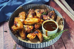 Anja Würfl/die-frau-am-grill.de/dpa-tmn | Damit nichts in die Glut tropft, empfiehlt sich für die Chicken Wings eine sämige Marinade aus Trockengewürzen.