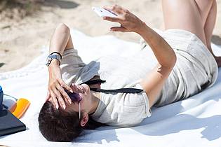 Christin Klose/dpa-tmn | Hot out there: Damit das Smartphone bei Hitze keinen Schaden nimmt, legt man es besser in den Schatten.