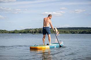 Benjamin Nolte/dpa-tmn | Stand-up-Paddling ist ein Ganzkörpertraining, bei dem die Muskulatur in Armen, Rücken und Rumpf gestärkt wird.