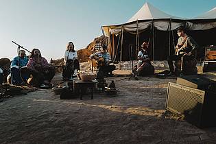 Korbinian Maier/ZDF/dpa | Die Band Juli performt in der Wüste Marokkos mit Einheimischen bei Sonnenuntergang. (Szene aus «Song Trip: Juli x Marokko»/ZDF-Streamingportal).