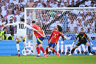 Tom Weller/dpa | Jamal Musiala schießt - und Spaniens Marc Cucurella wehrt den Ball im EM-Viertelfinale mit dem abgespreizten Arm ab.