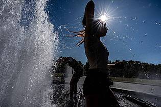 Michael Kappeler/dpa | Temperaturen von annähernd 40 Grad in der Hauptstadt - diese Touristen nutzen einen Brunnen zur Abkühlung.